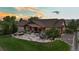 Expansive backyard features stone patio with a built-in fire pit and seating, manicured lawn, and the house at sunset at 7130 Independence St, Arvada, CO 80004