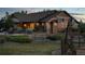 View of a home featuring rustic exterior, outdoor seating area, windmill and lush landscaping, exuding charm at 7130 Independence St, Arvada, CO 80004