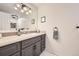 Well-lit bathroom featuring a gray vanity with modern fixtures and decorative accents at 7552 Miller Ct, Arvada, CO 80005