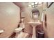 Charming powder bathroom featuring a decorative mirror, pedestal sink, and modern toilet at 7552 Miller Ct, Arvada, CO 80005