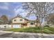 Well-maintained two-story home with mature trees, a lush lawn, and a welcoming front entrance at 7552 Miller Ct, Arvada, CO 80005