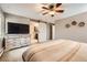 Bedroom featuring an ensuite bath, dresser, ceiling fan, and neutral decor at 7552 Miller Ct, Arvada, CO 80005