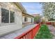 The home features a red fence surrounding the concrete back patio area at 23730 E Otero Dr, Aurora, CO 80016