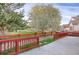 View of the community's back yard, with a red fence, green grass and flowering trees at 23730 E Otero Dr, Aurora, CO 80016