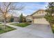 Well-manicured house featuring a spacious driveway, two-car garage, and vibrant green lawn at 23730 E Otero Dr, Aurora, CO 80016