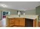 Practical kitchen with wooden cabinets, a dishwasher, and an open view to the living area at 23730 E Otero Dr, Aurora, CO 80016