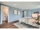 Light filled primary bedroom with wood floors, ensuite bath and neutral paint at 2729 E Geddes Pl, Centennial, CO 80122