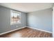 Empty room with light grey walls, white trim, wood floors and large window at 2729 E Geddes Pl, Centennial, CO 80122