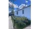 Side view of home with white siding, bushes, and narrow walkway at 3816 W Dakota Ave, Denver, CO 80219