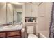 Compact bathroom with a vanity, toilet with storage, and a combined shower and tub area at 20530 Randolph Pl, Denver, CO 80249