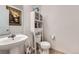 Bathroom with toilet, sink, cabinet and decorative painting at 20530 Randolph Pl, Denver, CO 80249