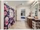 Bright bathroom with a floral shower curtain, a wooden vanity with sink and a view into bedroom at 20530 Randolph Pl, Denver, CO 80249