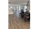 Open dining area with hardwood floors, a dark wood dining table with stools, and plentiful natural light at 20530 Randolph Pl, Denver, CO 80249
