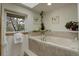 Bathroom featuring a soaking tub under a skylight and picturesque window at 1460 Quince Ave # 102, Boulder, CO 80304