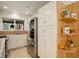Modern kitchen with stainless steel refrigerator, white cabinets, and open shelving, offering both style and functionality at 1460 Quince Ave # 102, Boulder, CO 80304