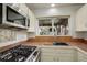Charming kitchen with stainless steel gas range, a microwave, and a window above the sink that invites natural light at 1460 Quince Ave # 102, Boulder, CO 80304