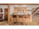 Well-equipped bar with wood cabinets and leather barstools at 10037 Allison Ct, Broomfield, CO 80021
