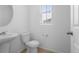 Modern half bathroom with a pedestal sink and natural light at 1697 S Andes Way, Aurora, CO 80017