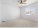 Bright, carpeted bedroom featuring a ceiling fan and a window, offering a serene space at 1697 S Andes Way, Aurora, CO 80017