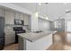 Open kitchen featuring a center island, gas range, and modern cabinetry at 1697 S Andes Way, Aurora, CO 80017