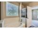 Full bathroom with a tub and showerhead, white tiling, and an open doorway at 8083 W 51St Pl # 203, Arvada, CO 80002