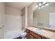 Full bathroom boasts a vanity, sink, mirror, updated fixtures, and tiled tub at 8083 W 51St Pl # 203, Arvada, CO 80002