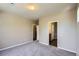 A bright bedroom with grey carpet has an open door to the bathroom and kitchen at 8083 W 51St Pl # 203, Arvada, CO 80002