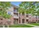 Beautiful condo building with stone accents, balconies, and lush landscaping at 8083 W 51St Pl # 203, Arvada, CO 80002