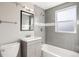 Modern bathroom with a gray tiled shower and bathtub, a sleek vanity, and ample natural light offering a serene space at 6002 E 29Th Ave, Denver, CO 80207