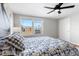 Bright bedroom with a patterned bedspread, a large window, and a ceiling fan providing a cozy and inviting retreat at 6002 E 29Th Ave, Denver, CO 80207