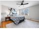 Serene bedroom with a patterned bedspread, bright natural light, and a ceiling fan creating a comfortable and inviting space at 6002 E 29Th Ave, Denver, CO 80207