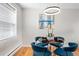 Inviting dining area with a round table, comfortable blue chairs, and a modern light fixture creating a welcoming atmosphere at 6002 E 29Th Ave, Denver, CO 80207