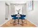 Bright dining area with stylish blue chairs, modern lighting, and hardwood floors at 6002 E 29Th Ave, Denver, CO 80207