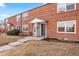 Traditional brick townhome exterior with tidy front lawn and covered entryway at 6002 E 29Th Ave, Denver, CO 80207