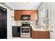 Well-lit kitchen with stainless steel appliances, granite counters, and wood cabinets at 6002 E 29Th Ave, Denver, CO 80207