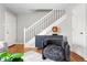 Cozy living room featuring modern decor, a stylish accent chair, and a staircase creating a chic and comfortable ambiance at 6002 E 29Th Ave, Denver, CO 80207