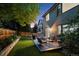 Backyard with patio, furniture, grill, and garden framed by lush greenery at dusk at 13132 Pennsylvania Cir, Thornton, CO 80241
