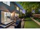 Backyard patio with grill, seating, and manicured lawn leading into home at twilight at 13132 Pennsylvania Cir, Thornton, CO 80241