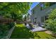 Manicured backyard with patio and grill, framed by landscaping, greenery and a fence at 13132 Pennsylvania Cir, Thornton, CO 80241
