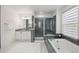 Large primary bathroom featuring a double vanity, soaking tub, and glass shower enclosure at 13132 Pennsylvania Cir, Thornton, CO 80241