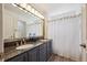 Double vanity bathroom with granite countertops, modern lighting and framed mirror above at 13132 Pennsylvania Cir, Thornton, CO 80241