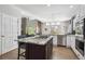Open kitchen layout with a center island, stainless steel appliances, and hardwood flooring at 13132 Pennsylvania Cir, Thornton, CO 80241