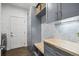 A mudroom features gray custom cabinetry, wood countertop, wallpaper, and laundry machines at 13132 Pennsylvania Cir, Thornton, CO 80241