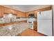 Updated kitchen with an island, granite countertops, modern appliances, and wood floors at 3451 Highland Pl, Westminster, CO 80031