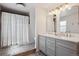 Well-lit bathroom with a shower, updated vanity with double sinks and mirrors, and decorative patterned tile at 4179 E Peakview Cir, Centennial, CO 80121