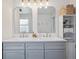 Bathroom with double sinks and mirrors over a gray vanity, with shelving providing storage options at 4179 E Peakview Cir, Centennial, CO 80121