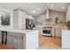 Modern kitchen features white cabinets, an island with seating, stainless steel appliances, and light hardwood floors at 4179 E Peakview Cir, Centennial, CO 80121