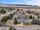 Stunning gray two-story home featuring a white fence, lush lawn, mature trees, and picturesque mountain views at 5753 Secrest Ct, Golden, CO 80403