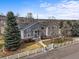 Charming home with stone accents, a manicured lawn, mature trees, and a white picket fence at 5753 Secrest Ct, Golden, CO 80403