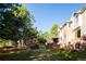 Expansive backyard featuring large trees, an open grass lawn, and a multi-story brick home at 924 Glen Oaks Ave, Castle Pines, CO 80108